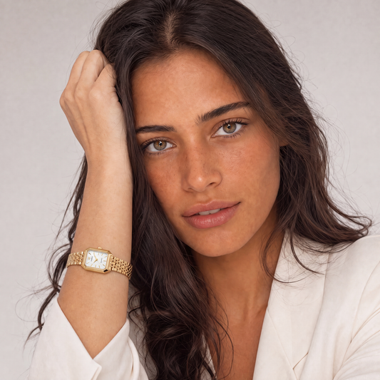 Le Marais Watch Lumière worn on model wrist, gold tone women's watch styled with a white blazer