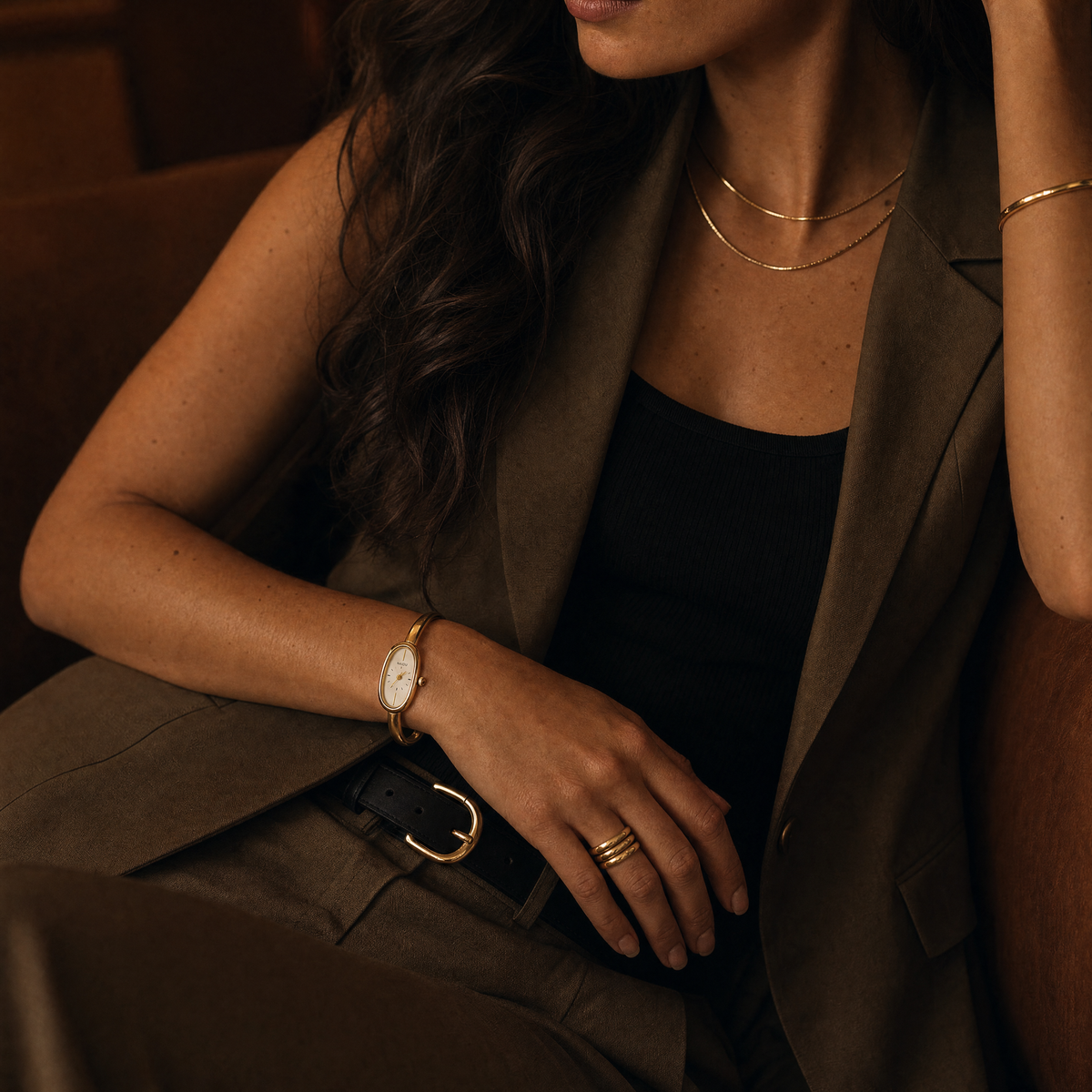 Passy Watch Gold on model wrist in a moody lifestyle shot with an olive suit